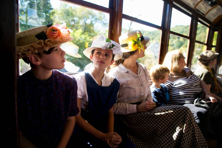 Trolley Era reenactors Mabel Kingsley, 11, from left, Allie Martin, 11, and Sophia Rehmus ride Trolley No. 10 with passengers during the annual Trolleyfest at the Shelburne Falls Trolley Museum in 2018.