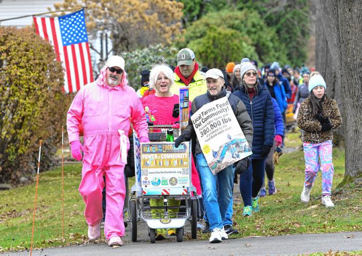 The 14th annual March for the Food Bank with Monte Belmonte, pictured second from left, makes its way up North Main Street in South Deerfield on Tuesday.