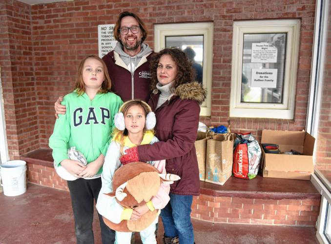 The Haffner family of Buckland — Grant, Cassandra and their children Griffin, 11, and Phoenix, 9 — stand in the lobby of Buckland-Shelburne Elementary School where people have been dropping off donations for the family. They lost everything in a fire on Saturday.