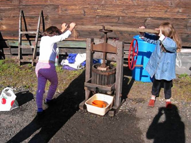 Children using the ciderpress at previous Trolleyfest celebrations.