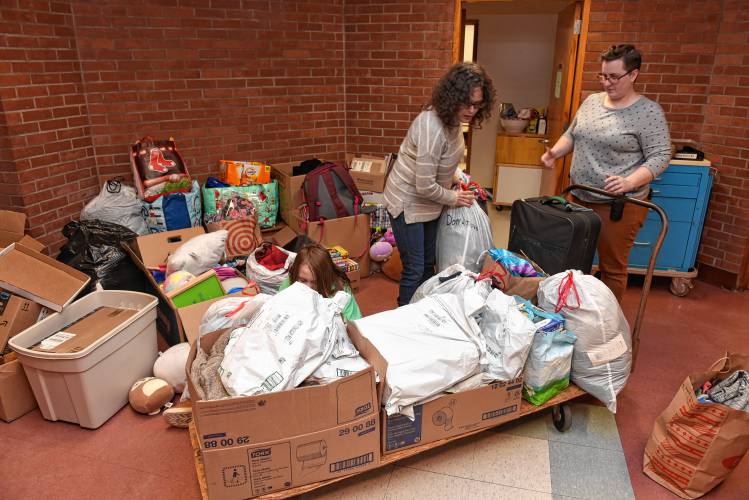 Cassandra Haffner and Buckland-Shelburne Elementary School Principal Hayley Gilmore load a cart with donations for the Haffners, who lost everything in a fire on Saturday.