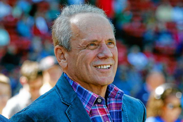 Boston Red Sox president and CEO Larry Lucchino watches a video tribute before a baseball game between the Red Sox and the Baltimore Orioles in Boston, Sunday, Sept. 27, 2015. Lucchino, the force behind baseball’s retro ballpark revolution and the transformation of the Boston Red Sox from cursed losers to World Series champions, has died. He was 78.