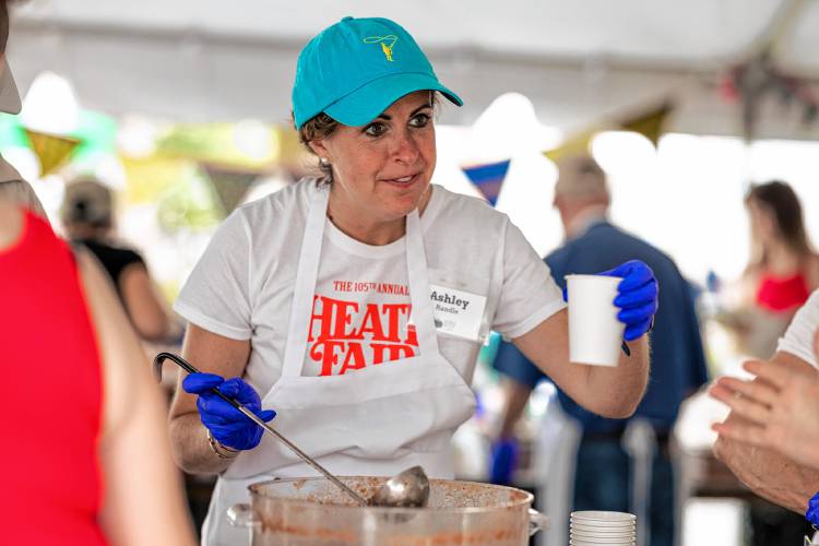 Volunteer Ashley Randle serves gazpacho at Saturday’s Harvest Supper.