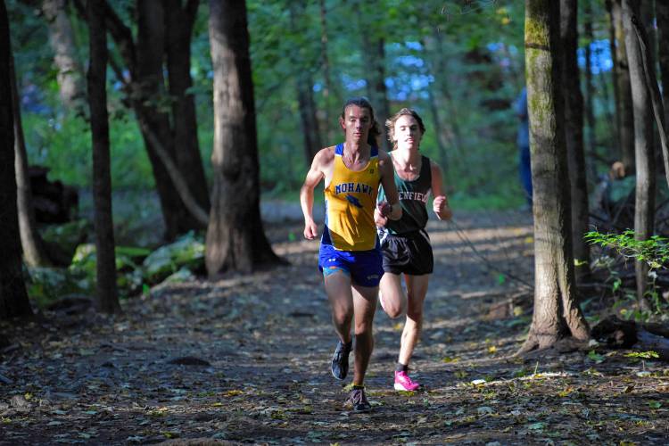 Mohawk Trail’s Vincent Gauthier and Greenfield’s Jackson Caron enter the woods at Highland Park on Tuesday afternoon. 