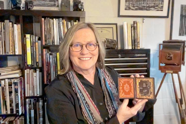 Turners Falls photographer Terri Cappucci is seen in her studio with a framed tintype. Cappucci has donated a large collection of antique plate glass negatives she had previously received to UMass Amherst.