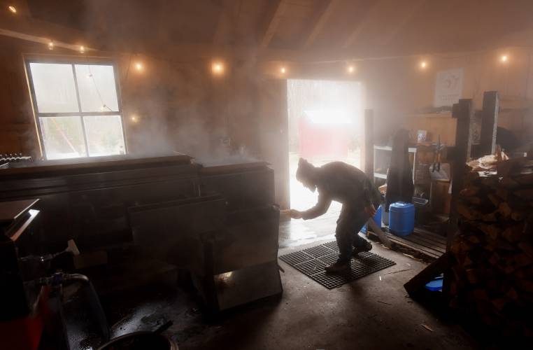 Rich Valcourt of Valcourt Sugar Shack in Petersham is surrounded by steam as he loads wood into his evaporator, boiling down sap from his 1,400 taps in the North Quabbin area.