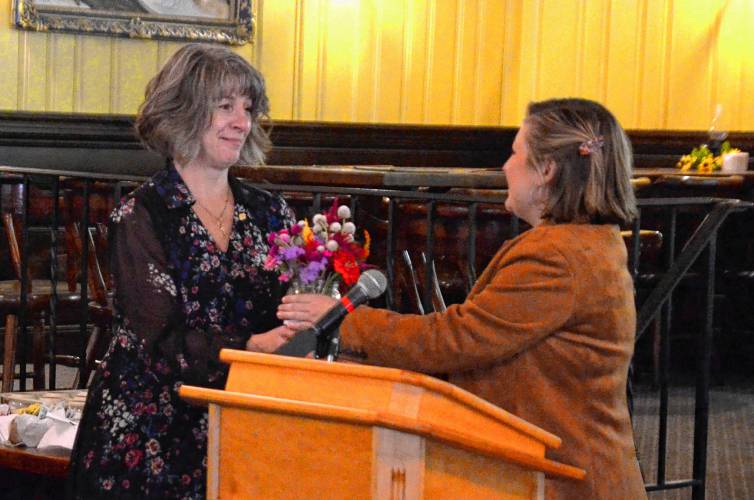 Erving Town Planner Mariah Kurtz gives flowers to Oxford resident Stacey Hamel toward the end of a reception held Thursday at the French King Restaurant recognizing the complete installation of safety barriers at the French King Bridge. Hamel, whose stepson, Bryan Hamel, is suspected to have jumped from the French King Bridge in 2018, has been a primary advocate for the project.