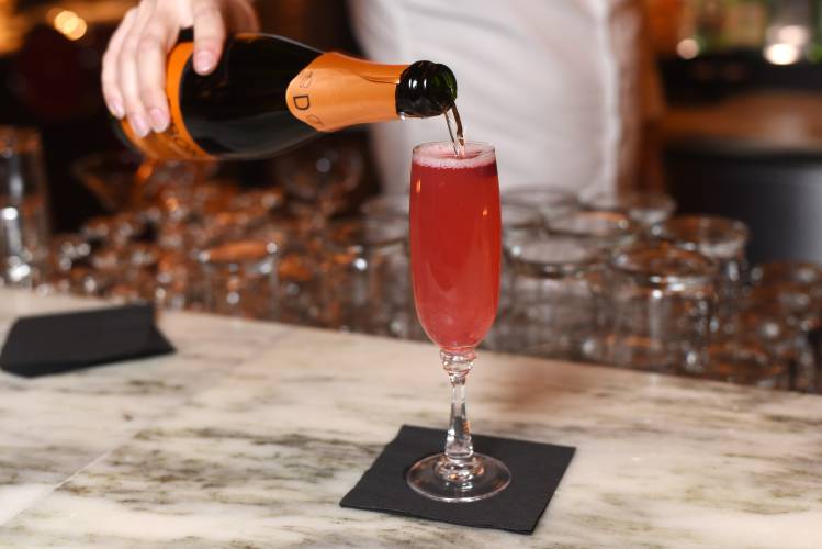 Ethan Bray, front-of-house manager at The Farm Table in Bernardston, makes a Crimson Nova using elderflower gin, cranberry and sage shrub, and lemon. It is topped with a Spanish sparkling wine named cava that is similar to champagne.