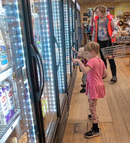 Abel Reagan, 4, Etta Reagan, 2, and their mother Samantha Spisiak shop at the Leverett Village Co-Op for afternoon snacks Tuesday afternoon, Dec. 19. 