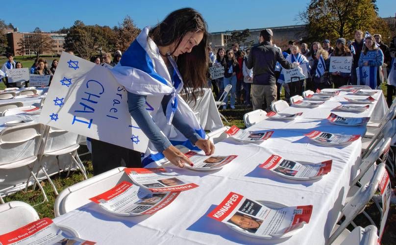 Sarah Rosen tapes plates to tables during an event sponsored by UMass Hillel called “Bring Them Home.”