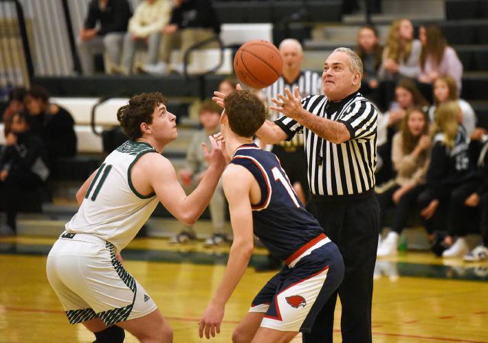 Referee Mark Grumoli tosses the ball up for the start of a Greenfield vs Frontier basketball game at Nichols Gymnasium in Greenfield.