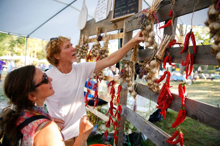 Jon Holland and Lisa Bouchie, of Orange, pick out handmade garlic braids for sale at a previous Garlic and Arts Festival.