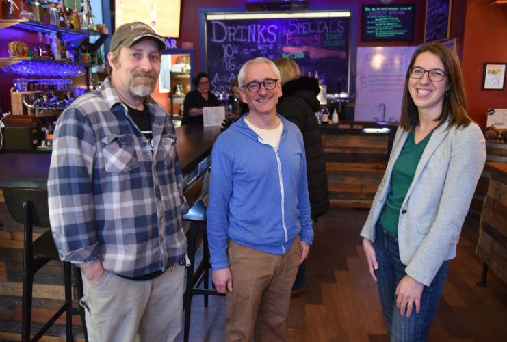 Co-owners Ben Anhalt and Dan Kramer of Element Brewing Co. in Millers Falls, pictured with Sara Lark, a member of the Friends of the Greenfield Public Library, in January 2023. The Friends group will host its next Pints for Programs fundraiser at the brewery on Thursday, March 14.