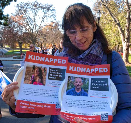 Iris Berkman holds a plate with a picture of one of her relatives, right, during an event sponsored by UMass Hillel called “Bring Them Home.” Participants carried plates with flyers that were attached. Each flyer had a picture of one of the 240 hostages kidnapped from Israel by Hamas. Each plate was than taped to tables in a symbolic ritual of Shabbat honoring the hostages.