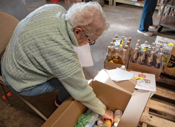 Donna Zimmerman, a volunteer at the Leverett Village Co-Op, checks a recent delivery.