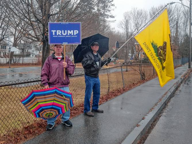 Ray Younghans, left, and Lou Maldonado stand outside in support of Republican presidential candidate Donald Trump near 62 Cheney St., where Orange’s polls were located.